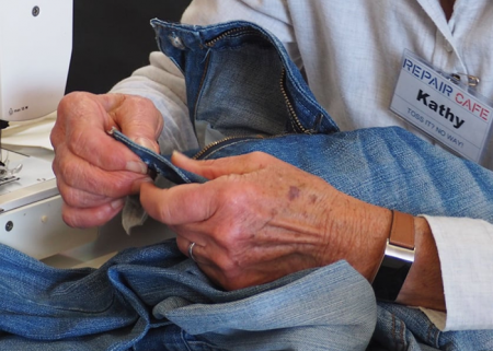A close up of some hands repairing some jeans.