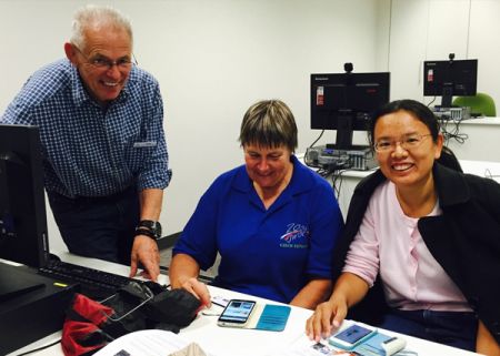 Library volunteers assisting people with computer troubles.