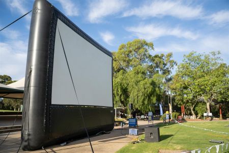 A side on view of the outdoor movie screen at Movies in the Park 2022