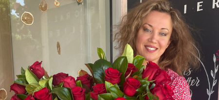 A woman holding a bunch of red roses.