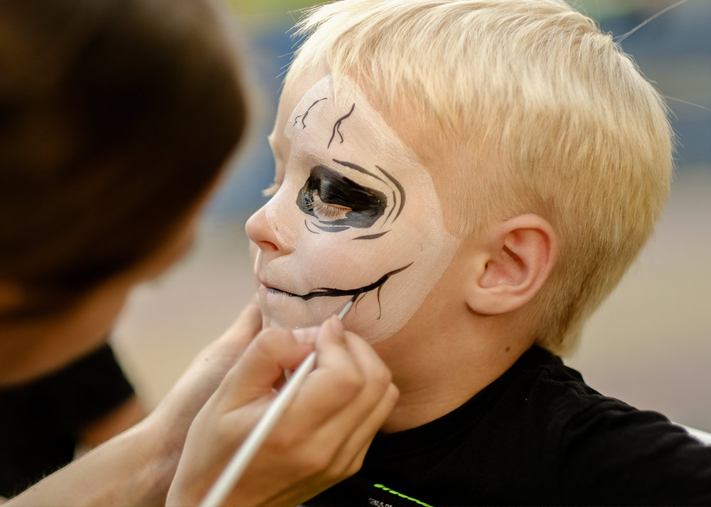 A child getting their face painted for Halloween