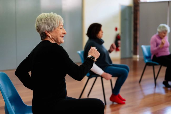 Older women participating in a seated dance class.