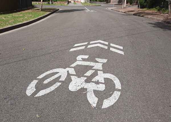 Image of painted bicycle sharrow symbol on road.