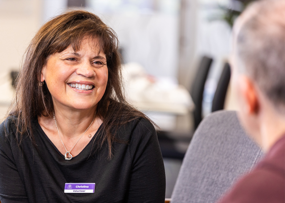 A woman smiling while chatting to a man.
