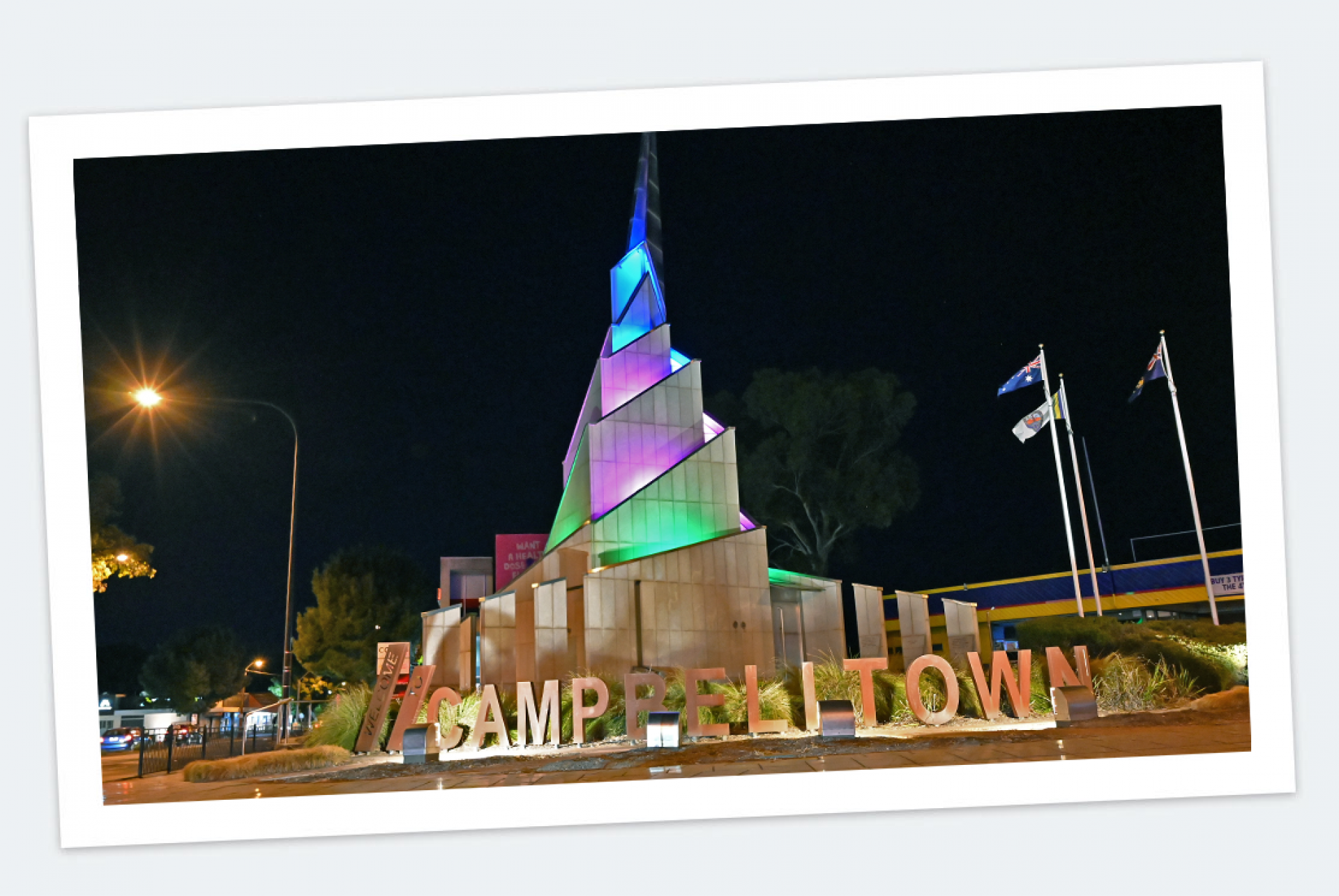Migrant Monument in Campbelltown lit up at night.