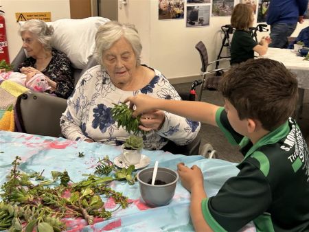 Students from Thorndon Park Primary school making succulent teacups with residents of Resthaven Paradise.