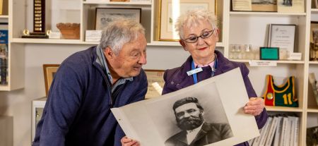 Two people looking at an old photograph in the Local History Room.