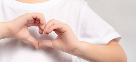A child's hands making the shape of a heart.