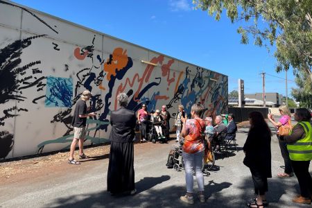 A group of people celebrating the launch of 'Ollie's Mural' at Paradise Recreation Plaza.