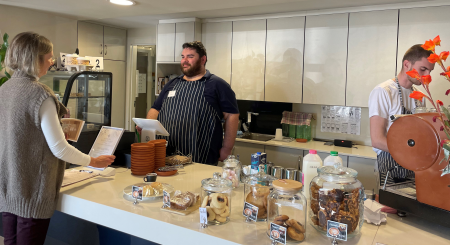 A staff member serving a customer at a cafe.