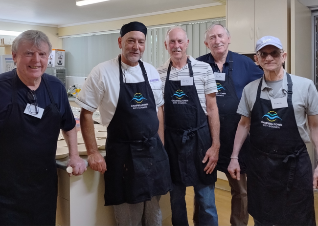 Men wearing aprons at the Magill Community Centre's men's cooking class.