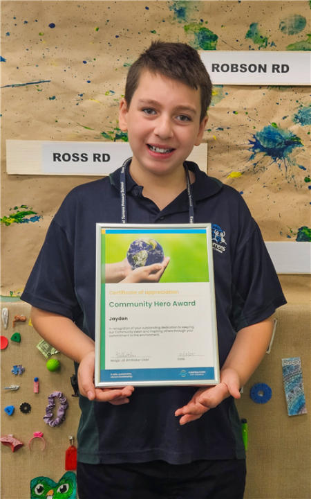 Jayden proudly holding his 'Community Hero Award'.