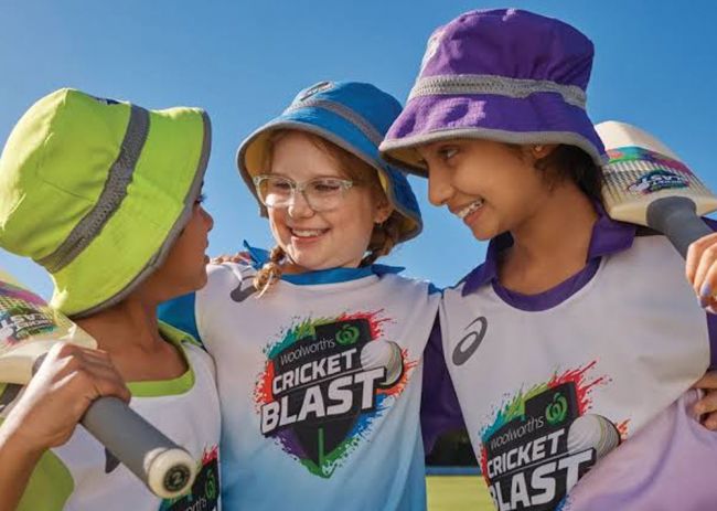 Children wearing 'Woolworths Cricket Blast' T-shirts and holding cricket bats.