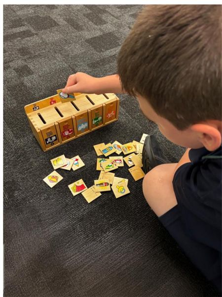 Jayden sorting items into the correct recycling bins.