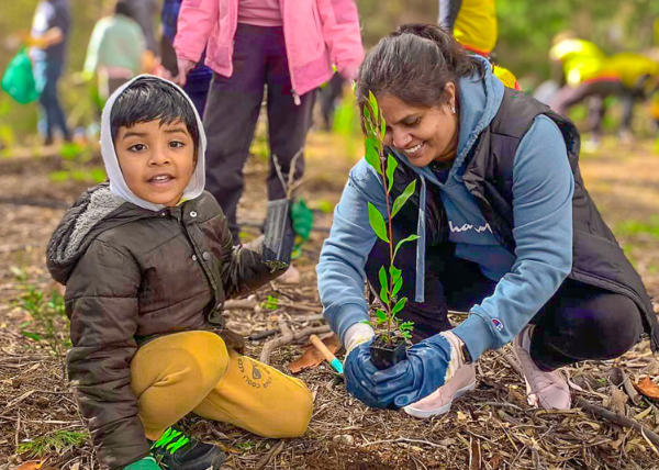 A mother and child planting a tree.