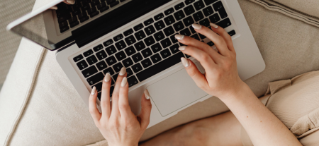 A woman's hands using a laptop.
