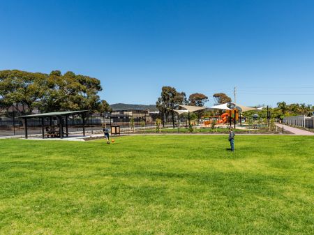 Children playing soccer on the grass at Playford Road Reserve